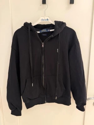 Svart raulph lauren zip-hoodie - Svart stilig raulph lauren hoodie, tröjan är i storlek S men skulle sjölv säga att den passar som XS. I verkligheten är den lite mörkare än vad den är på bilderna och även utmärkt kvalité. Nästan oanvänd. Pris kan diskuteras 