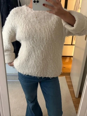 Vit fluffig stickad tröja - Mysig vit stickad tröja med fluffig textur. Perfekt för kyliga dagar när du vill vara både varm och snygg.🤍