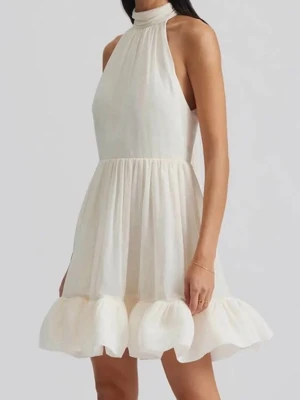 Vit kortklänning från By Malina - Supersöt vit kortklänning från Malina med hög hals, volangkant nertill och stor rosett i nacken. Klänningen är ärmlös och har en luftig, flowy passform som ger en romantisk vibe. Perfekt för sommarens alla tillfällen och speciellt till studenten 🥳🥳🥳🥳