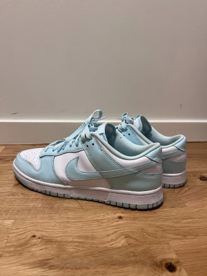 Nike Dunk Low Glacier Blue, 44  - Säljer mina Nike Dunk Low Glacier Blue i storlek 44 US 10. Skorna är i mycket fint skick / nyskick, sparsamt använda och väl omhändertagna.  Klassisk Dunk Low-modell med bekväm passform och tidlös design. Köpta på Nike Store Gallerian i somras för 1900kr.   Skokartong finns inte.