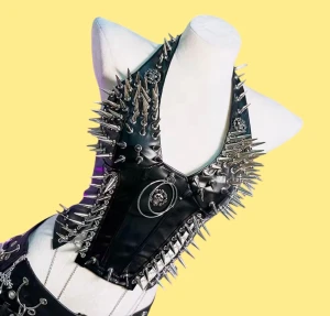 Svart top med spikes och kedjor - Unik svart väst i syntetmaterial med massor av silverfärgade spikes och detaljerade dödskalledekorationer. 