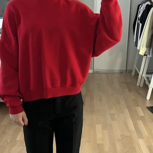 Röd oversized sweatshirt XS - Röd sweatshirt i oversized modell från nelly med ribbade muddar vid ärmslut och midja. Ett litet missfärgat streck på framsidan som knappt syns, (sista bilden). 