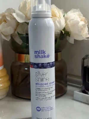 Milk Shake Silver Shine Whipped Cream - Silvermousse för blont eller grått hår som återfuktar och ger glans. Innehåller pigment som neutraliserar gula och gyllene toner. Berikad med ekologiskt blåbärsextrakt och mjölkprotein. Kommer i en vit flaska med lila detaljer, 200 ml.