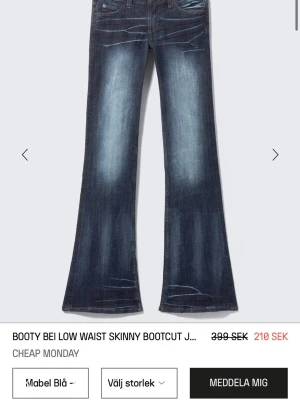 Mörkblå bootcut jeans med slitningar - Säljer ett par mörkblå bootcut jeans med snygga slitningar och tvättade detaljer på benen. Jeansen har en klassisk femficksmodell och är tillverkade i ett robust denimtyg som ger en cool vintagekänsla.Som även är helt slutsålda 