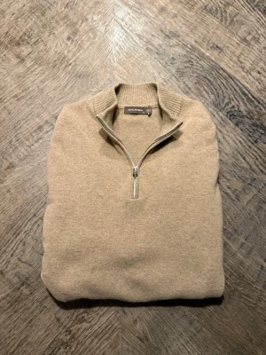 Beige half zip tröja Oscar Jacobson - Snygg beige tröja från Oscar Jacobson. Kashmir blandning, perfekt för vintern/våren.  Personen på bilden är 195 och är lite kort. Skulle säga att 180-190 är perfekt! Nypris: 1699. Hör av dig vid minsta fråga!