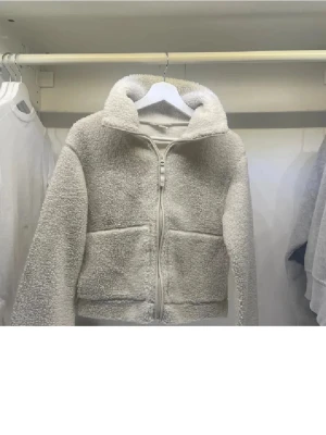 Vit teddyjacka med dragkedja - Mysig vit teddyjacka med hög krage och två stora fickor framtill. Jackan är själv köpt här på plick för ca 500kr. Den har den har så gott som inga tecken på användning!!!❤️