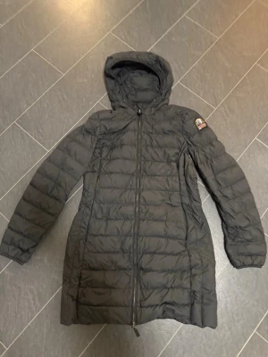 Svart dam dunjacka från Parajumpers L - Nu säljer jag min svarta långa dam dunjacka från Parajumpers i storlek L. Jackan är superlätt, har huva, dragkedja framtill och ett broderat märke på ärmen. Håller värmen ordentligt trots det tunna, lätta materialet. Köpt 2022 för 5900kr och är fortfarande i nyskick. Inga skador, hål eller liknande. Hör av er vid intresse så kanske vi kan komma överens om ett lägre pris. 