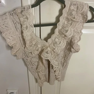 Beige spetsblus från Zara - Supersöt beige blus från Zara med breda volangdetaljer och v-ringning. Blusen är stickad med spetsinslag  . 