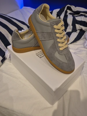 Grå Maison Margiela storlek 42 - Sprilans nya Maison Margielas i storlek 42.         Väldigt detaljerade med läder i högsta klass och äkta suede.