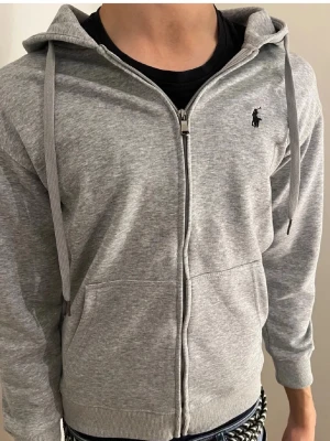 Grå Ralph luaren hoodie  - Grå Ralphlauren hoodie i S. Tröjan är i nyskick kan man säga. Vid snabb affär så löser vi sjysst pris.