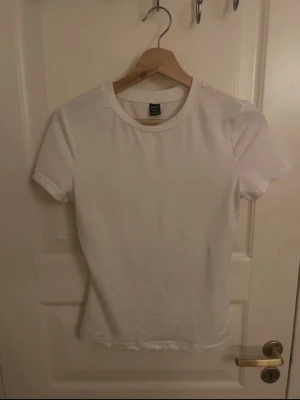 Vit basic t-shirt från SHEIN - Enkel och stilren vit t-shirt från SHEIN i storlek S. Modellen har rund halsringning och korta ärmar.