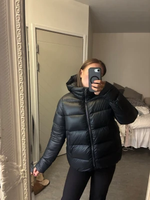 Svart Colmarjacka - Säljer en svart pufferjacka från Colmar i storlek 48, (som en S) Jackan har en avtagbar luva och dragkedja framtill. Den är perfekt till vintern och man håller sig varm! Super fint skick utan några defekter! Priset är inte spikat i sten!💓