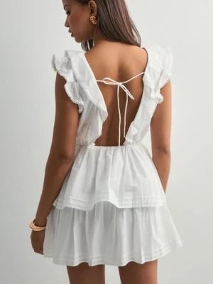 Vit volangklänning med öppen rygg - Supersöt vit kortklänning med volanger och v-ringning. Klänningen har öppen rygg med knyte så den går enkelt att anpassa. Perfekt till studenten 🙌🏼