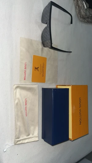 Louis Vuitton monogram solglasögon - Säljer ett par svarta Louis Vuitton solglasögon med ikoniskt monogrammönster på glaset. Modellen har breda skalmar med Louis Vuitton-logga och kommer med originalfodral, putsduk och box. Riktigt statement-piece för dig som gillar lyxig och trendig stil.