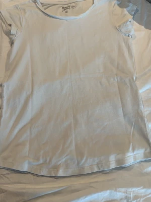 Vit basic t-shirt från gekås - Enkel vit t-shirt från gekås med rund hals och korta ärmar. Tillverkad i mjuk bomull som känns skön mot huden. Perfekt att matcha med jeans eller shorts för en clean och avslappnad look.