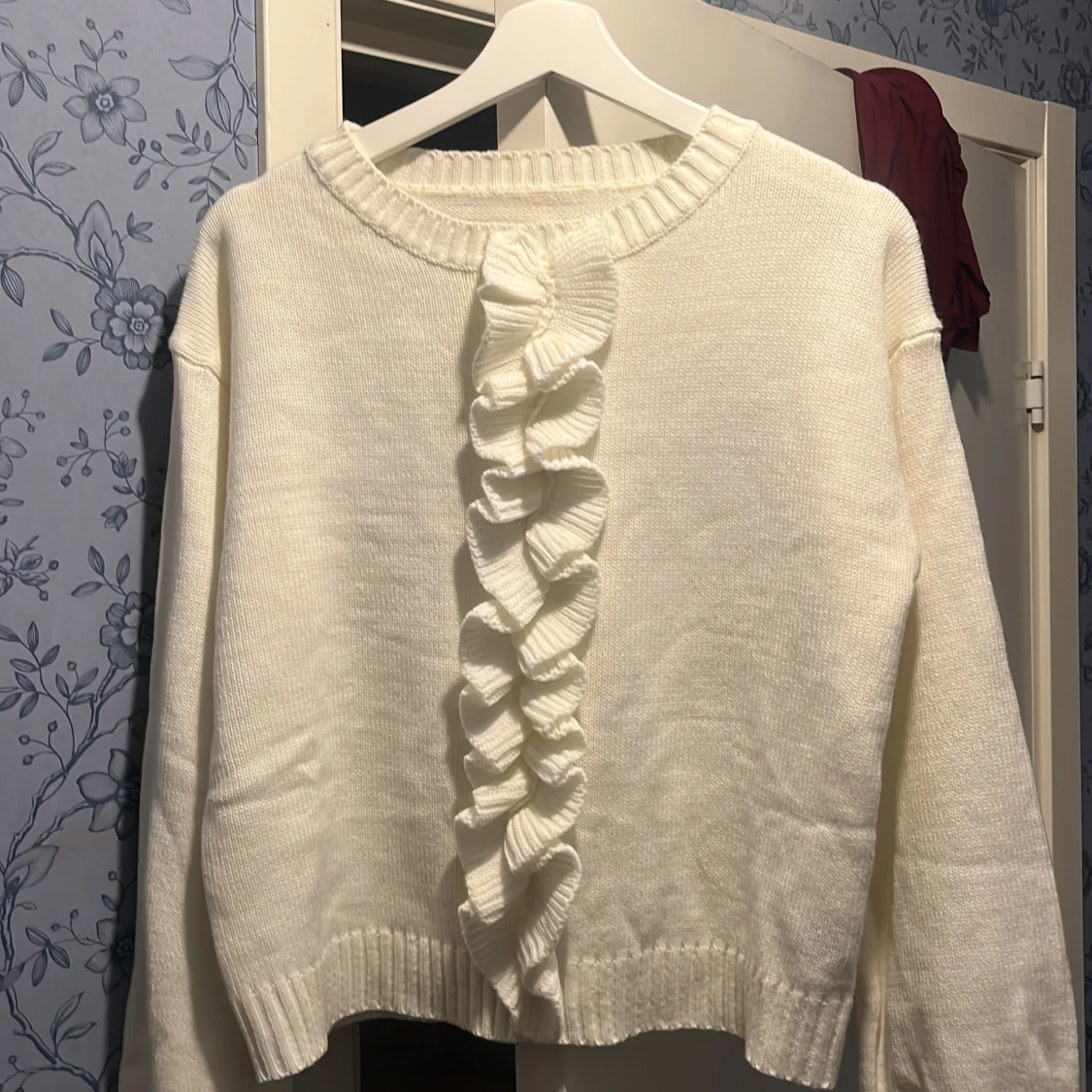 Vit stickad tröja med volangdetalj