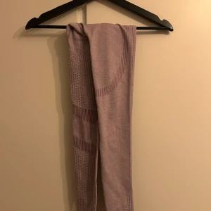 Ljusrosa seamless leggings från ICIW - Säljer ett par ljusrosa seamless leggings från ICIW med ribbade detaljer och diskret logga vid midjan. De är stretchiga och har en tight passform, perfekta för träning eller chill. Materialet är mjukt och följsamt syntetmaterial.