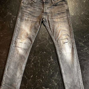 Grå slim jeans Jack & Jones 32/30 -  Gråa Slim Glenn jeans från Jack & Jones med slitningar. Perfekta nu till hösten och för er som gillar grisch stilen