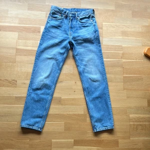 Blå relaxed jeans från H&M - Säljer ett par blå relaxed fit jeans från H&M i klassisk femficksmodell. Jeansen har normal midja, raka ben och är tillverkade i bomullsdenim. Perfekta för en chill och avslappnad stil.