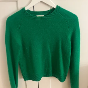 Grön kashmirtröja From Future - Snygg grön stickad tröja från From Future i mjuk kashmir. Klassisk rund halsringning, ribbade muddar och lång ärm. Perfekt för dig som vill ha en färgklick i garderoben och gillar en enkel men stilren look.