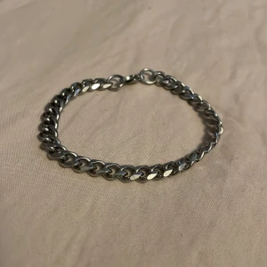 Kedjearmband i silverfärgad metall - Stilrent kedjearmband i silverfärgad metall med klassisk länkkedja och rundad form. Lätt att matcha med andra smycken och har en enkel låsning. Riktigt fräsch, äkta silver såklart. Hör av dig vid minsta fundering!