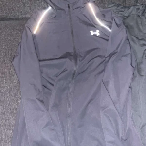 Grå jacka och byxor Under Armour - Snabb affär 1250 köpt för 2250 kr underarmour butik. Andvänd 2-3 gånger max som nya. Kommer som en dress/Set jacka och byxor.