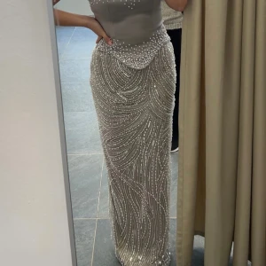 Glittrig silverlångklänning med pärlor - Säljer min klänning som är från Nederländerna. Använd bara en gång och är i jättefint skick! Storlek 34–36. Finns i Linköping/Södertälje men kan även skickas. Pris kan diskuteras vid snabb affär