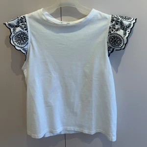 Vit tip med volang  - Säljer så fin topp från mango, som har volang vid ärmarna med mönster🤗