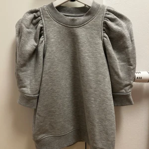 Grå sweatshirt med puffärm Second Female - Snygg grå tröja från Second Female i storlek XS. Tröjan har puffig ärm med rynkade axlar. 