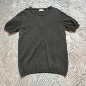Grå/Grön kashmirtröja Soft Goat M - Grå/Grön tröja Soft Goat i mjuk kashmir. Rund hals och korta ärmar. Ribbad kant vid hals, ärmslut och nederkant. 