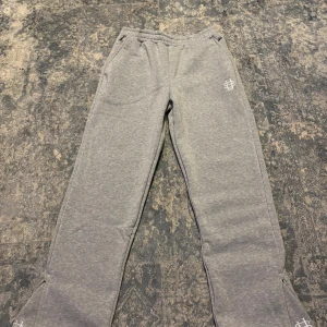 Grå mjukisbyxor med dragkedja vid foten - Grå mjukisbyxor. Byxorna har elastisk midja, sidofickor och dragkedja vid benslutet för extra stil. Perfekta för chill eller träning, riktigt sköna och snygga. Ej använda