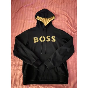 Boss hoodie - En stilren hoodie från Boss. Perfekt inför vintern. Storleken på hoodies är S men passar ändå M. Det är ett väldigt gott skick, cirka 8/10.