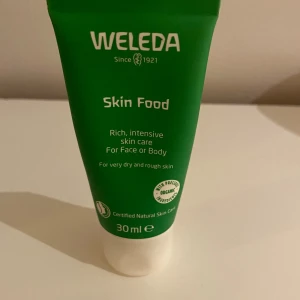 Weleda Skin Food 30ml - Weleda Skin Food är en intensivt återfuktande kräm i en grön tub på 30 ml, perfekt för både ansikte och kropp. Innehåller naturliga och ekologiska ingredienser som ger näring till torr och grov hud. Tuben är smidig att ta med och passar dig som vill ha mjukare hud.