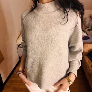 Stickat - Mjuk och mysig grå polotröja från H&M i storlek M. Tröjan har en liten krage, långärmade ärmar och är tillverkad i ett stickat material som känns skönt mot huden. Perfekt för att hålla sig varm under kyliga dagar.