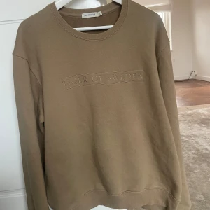 Beige sweatshirt från Tiger of Sweden - Beige sweatshirt från Tiger of Sweden med broderad logga framtill. 