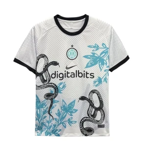 Inter Milan vit fotbollströja Nike - Inter Milan fotbollströja i vitt med svarta och blå detaljer, tryckt ormmotiv och bladmönster. Svart krage och ärmslut, digitalbits sponsorlogga på bröstet. Tillverkad i lätt och ventilerande material, perfekt för match eller träning.