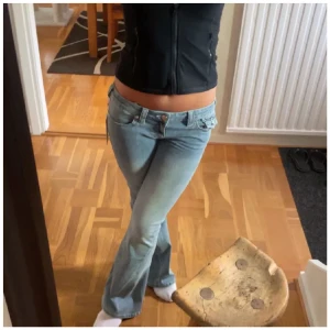 True Religion ljusblå bootcut jeans - Säljer ett par ikoniska ljusblå jeans från True Religion med snygga detaljer på bakfickorna och klassisk patch i midjan. Jeansen har bootcut-modell och låg midja, tillverkade i mjukt denimtyg. Jeansen är i jättebra kvalitet och skriv vid funderingar!❤️26/32 
