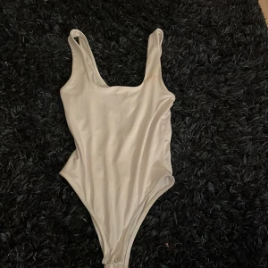 Vit body  - Säljer en vit body, formen är som ett linne där uppe. Går att knäppa där nere, köpt utomlands. Strl S