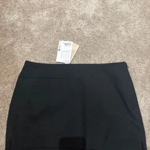 Svart mini kostym kortkjol från h&mxMonki, strl 36 - en stilren kortkjol från Monki i storlek 36. Kjolen har som en rak passform, den är helt oanvänd med prislappen på. Det ser ut som en kort kostym kjol, köpte den för 200kr💕