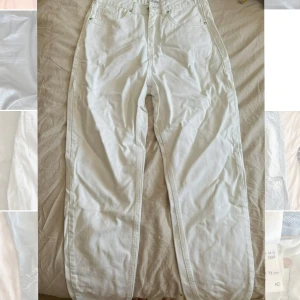 Vita raka jeans från Nakd - Säljer ett par vita jeans från Nakd i storlek 36. De har rak passform och är highwaist. På bakfickan finns en cool svart broderad design som ger byxorna en unik vibe. Perfekta för dig som gillar stilrena plagg med en twist.