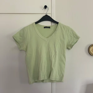 Ljusgrön v-ringad topp - Snygg ljusgrön t-shirt från Brandy Melville med v-ringad hals och korta ärmar. 