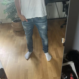 Dondup jeans - Säljer ett par blå Dondup jeans som är modellen George. Storleken är 32 och passform är slim fit. Hör av er vid funderingar. Obs: litet hål längs ner på jeansen 