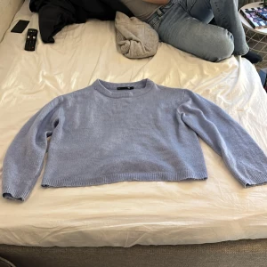 Ljusblå stickad tröja från 157 - Säljer en ljusblå stickad tröja från 157 i storlek S. Tröjan har en croppad passform, rund hals och långa ärmar. Mjuk och skön kvalitet som passar perfekt till jeans eller kjol. Enkel design utan mönster, med ribbade muddar vid hals, ärmslut och nederkant.