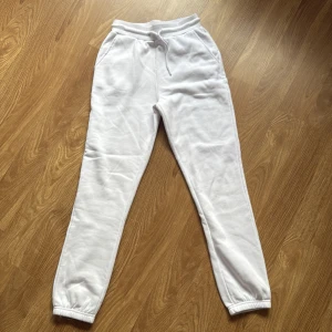 Vita mjukisbyxor från FB sister i storlek xss - Vita mjukisbyxor från FB sister i storlek XXS. Byxorna har resår och snörning i midjan, samt resår vid bensluten. Mjukt och skönt material, perfekta för chill dagar. Klassisk passform med fickor på sidorna.