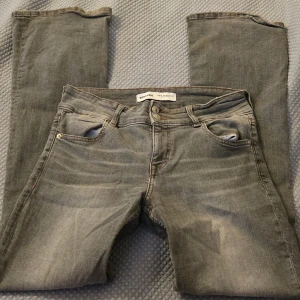 Grå jeans från Bershka - Säljer ett par grå jeans från Bershka med bootcut och klassisk femficksdesign. Jeansen har dubbla knappar i midjan och har mjukt och stretchigt material! Snygga till hösten och passar med tröjor, toppar och stickade tröjor!! Sköna jeans som passar till allt! Köpta i Spanien! Skriv om du är intresserad eller har några frågor!🫶🍁