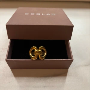 Guldfärgad ring från Edblad - Snygg guldfärgad ring från Edblad med chunky, design. Ringen har en modern och stilren look som sticker ut och passar perfekt för dig som gillar statement-smycken. Storlek 17,50