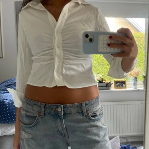 Vit croppad skjorta med knappar - Säljer en vit croppad skjorta med snygg rynkdetalj framtill och klassisk krage!💓🙌