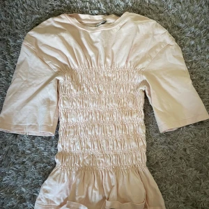 Ljusrosa topp från & other stories  - Toppen har rund hals och halvlånga ärmar, perfekt för en chill sommardag. Tillverkad i mjuk bomull som känns skön mot huden.