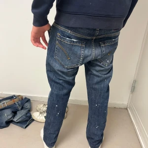  Dondup  - Snygga blå jeans från Dondup. Jeansen har orange kontrastsömmar, unika detaljer på bakfickorna och diskreta slitningar samt färgstark som gör dom lite extra stiliga. Perfekta för dig som gillar lite stiligare jeans 
