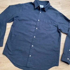 Mörkblå skjorta från NN07 i nyskick - Levon BD - Snygg mörkblå skjorta från NN07 i mjuk bomull. (Nyskick) Klassisk modell med krage, bröstficka och vita knappar framtill. Långärmad och passar perfekt till jeans eller chinos. Enkel och stilren design som funkar året runt. 